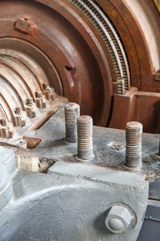 Close up detailed view of grey iron mechanical tools with screws, engine and brown coil.