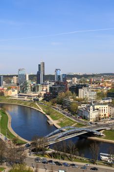 View of Vilnius city in Lithuania, with historical architectural structures, buildings around, with a flowing river, on blue clear sky background.