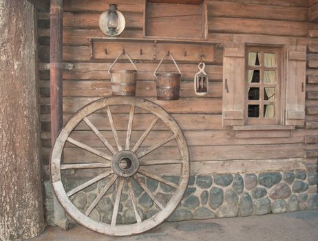 Wall of the old wooden house with household goods .