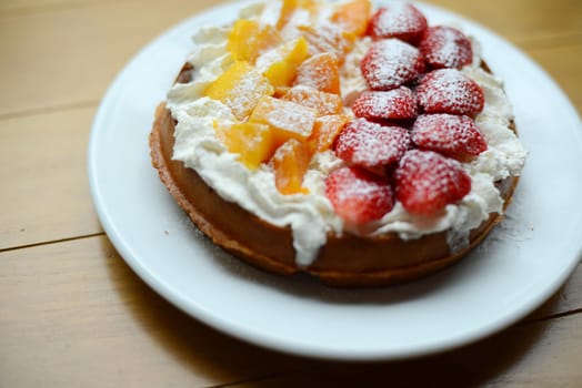 waffle pie decorated with whipped cream mango and strawberry
