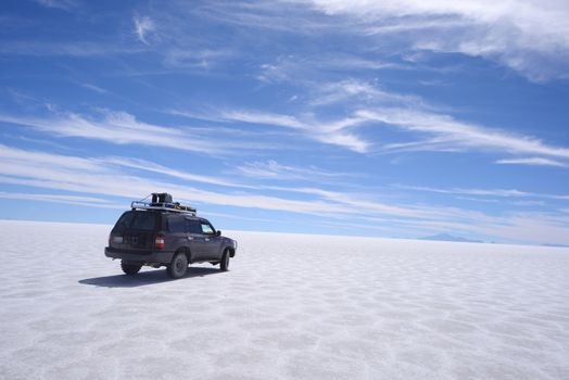 jeep travel in a large salt flat in uyuni, bolivia