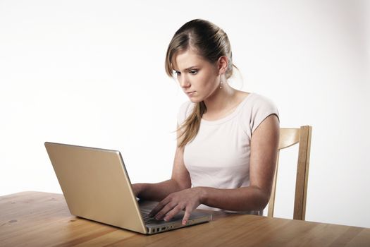 Young woman sitting at a table in front of her computer