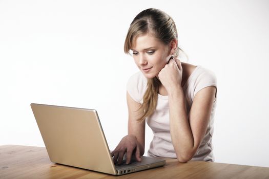 Young woman sitting at a table in front of her computer