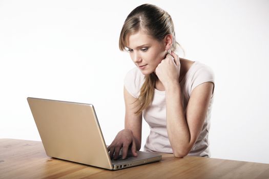 Young woman sitting at a table in front of her computer