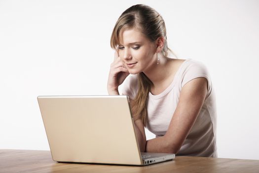 Young woman sitting at a table in front of her computer