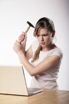 Woman strikes with a hammer to her computer