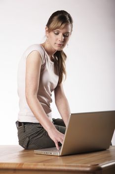 Young woman sitting at a table in front of her computer