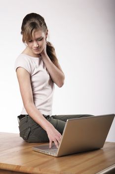 Young woman sitting at a table in front of her computer