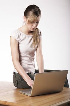 Young woman sitting at a table in front of her computer