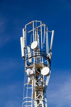 Cellular antennas on the top of the mast, close-up on a background of blue sky