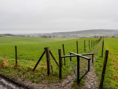 Cold, wet day overlooking empty meadows in the hills in Limburg