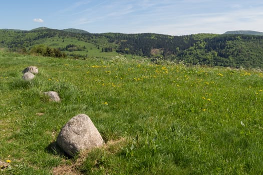 Sunny day looking past stones atop some Vosges hills in France