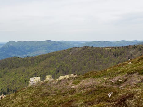 Looking past rocks at tree covered Vosges Hills