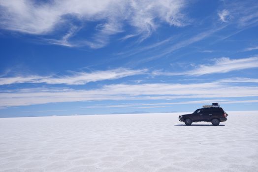 jeep travel in a large salt flat in uyuni, bolivia