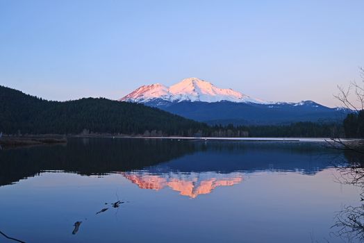 a reflection of mount shasta over a lake during sunset