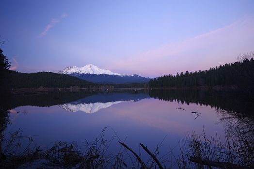 a reflection of mount shasta over a lake during sunset