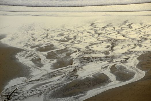 sand pattern from a creek flowing on a beach