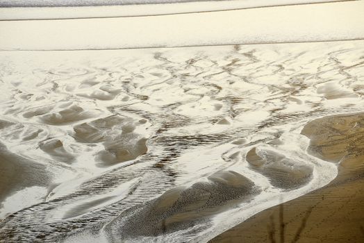 sand pattern from a creek flowing on a beach