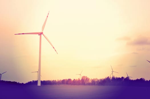 Windmills on the field. Vintage instagram picture. Alternative energy.