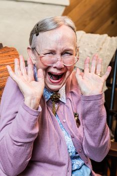 Happy old woman with a hands up gesture