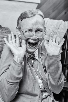 Happy elderly woman with a hands up gesture
