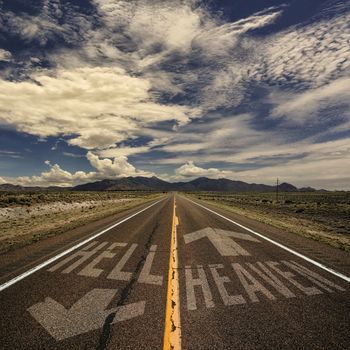 Conceptual image of two way road with arrows to heaven and hell