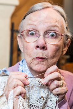 Elder woman with crochet and funny facial expression