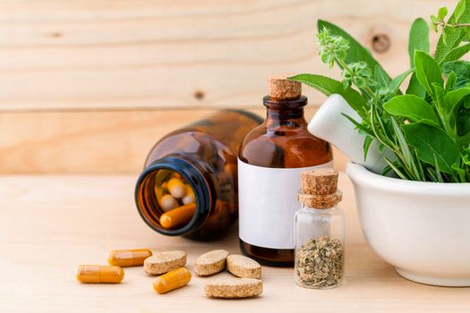 Alternative health care fresh herbal  ,dry and herbal capsule with mortar on wooden background.