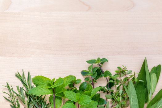 Fresh green herbs harvest from garden on wooden rustic background .