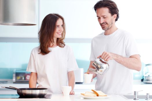 couple cooking breakfast at kitchen