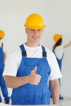workman gives thumbs up in front of two painters
