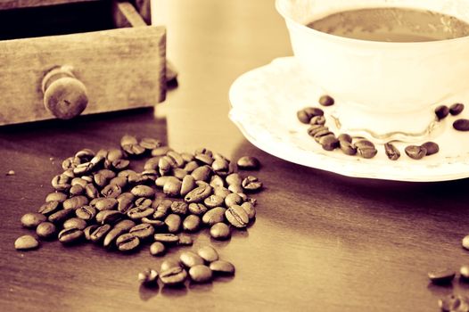 Coffee beans and cup of hot coffee. Vintage instagram picture.
