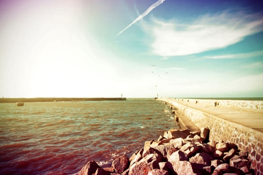 Coast and nature. Jetty at a sea and blue bright sky. Retro vintage instagram picture.