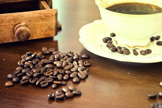 Coffee beans and cup of hot coffee. Vintage instagram picture.