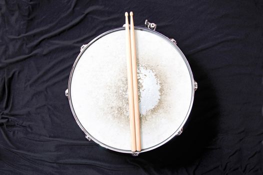 Drums conceptual image. Snare drum and stick over black background.