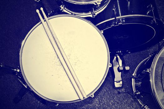 Drums conceptual image. Picture of drums and drumsticks lying on snare drum. Retro vintage instagram picture.