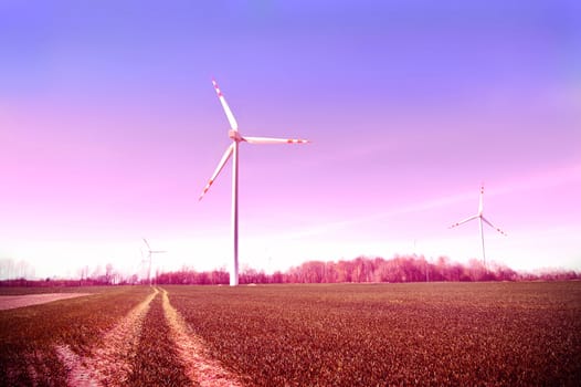 Windmills on the field. Vintage instagram picture. Alternative energy.