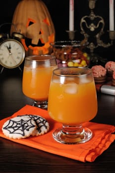 Pumpkin juice with ice on a napkin with cookies for Halloween