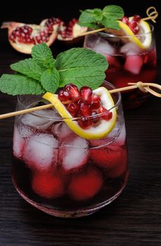 pomegranate drink with ice, a slice of lemon and mint