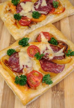 Mini pizza with vegetables, salami and cheese