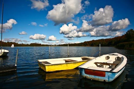 Colorful boats on a lake with cloudy blue sky in Denmark