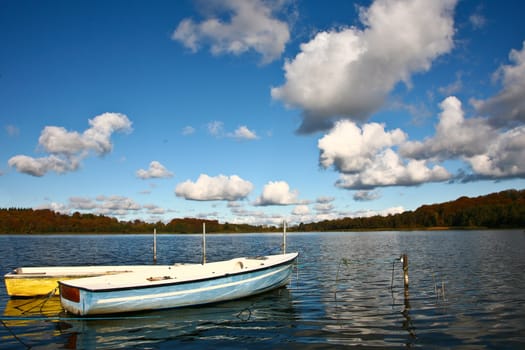 Colorful boats on a lake with cloudy blue sky in Denmark