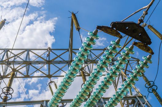 supports of high-voltage power lines against the blue sky