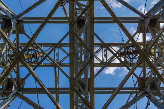 supports of high-voltage power lines against the blue sky