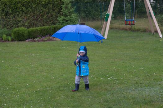 pretty little baby boy under rain