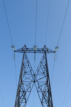 supports of high-voltage power lines against the blue sky