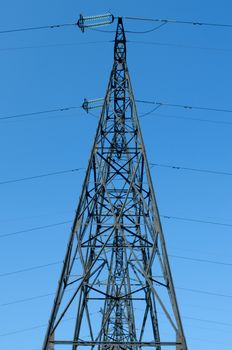 supports of high-voltage power lines against the blue sky