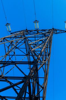 supports of high-voltage power lines against the blue sky