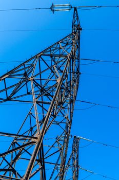 supports of high-voltage power lines against the blue sky