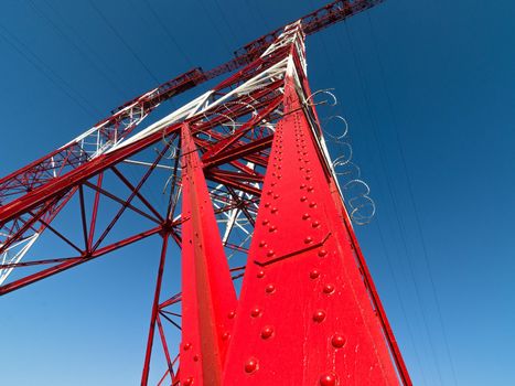 supports of high-voltage power lines against the blue sky